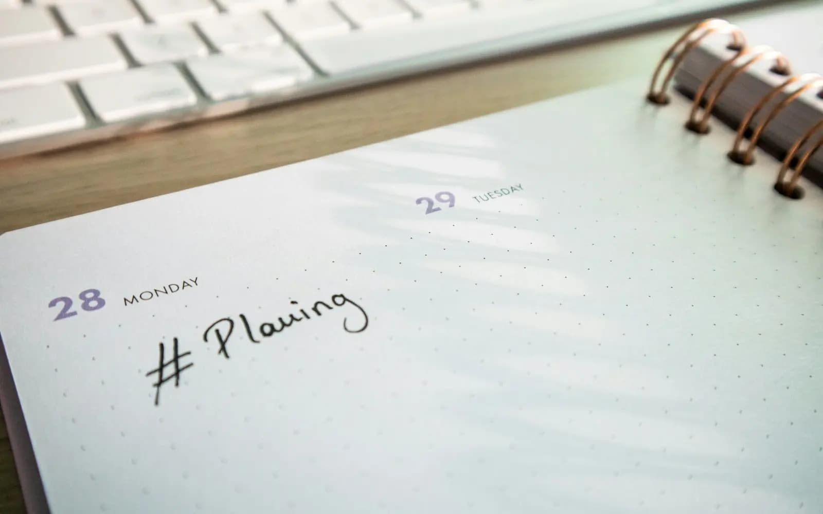 A blank paper planner lying open on a plain desk